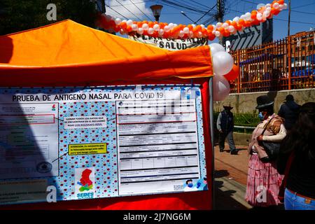 La Ceja, El Alto, Bolivien. 14.. April 2022. Auf einer Gesundheitsmesse in El Alto warten Menschen vor einem temporären Coronavirus-Testzentrum, das schnelle Covid-19-Antigen-Tests/Lateral-Flow-Tests anbietet. Auf der Seite ist ein Beispiel-Kontrollformular vom Gesundheitsministerium mit Anweisungen, die Menschen sagen, wie es auszufüllen. Stockfoto