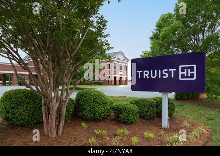 LEXINGTON, NC, USA-8 MAY 2022: Truist Bank, prominentes Zeichen und Sträucher mit Gebäude im Hintergrund. Stockfoto