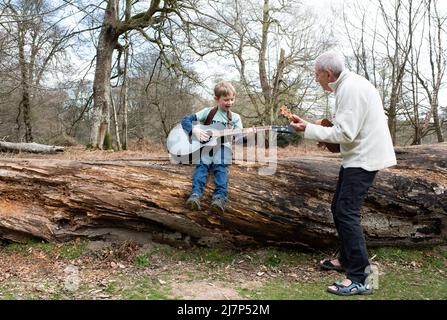 Großvater lehrt seinem Enkel, wie man Gitarre im Urlaub spielt Stockfoto