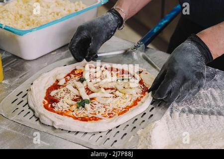 Ein Koch, der sich auf neapolitanische Pizzen spezialisiert hat, bereitet den Teig vor Stockfoto