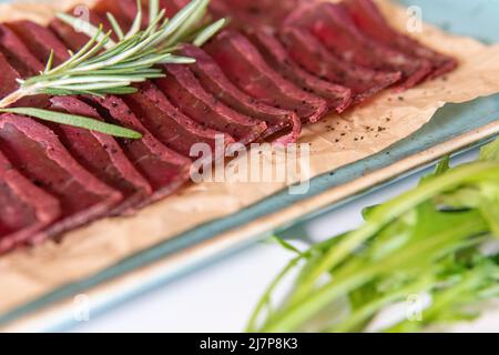 Pastrami auf einer blauen Platte mit Kirschtomaten Stockfoto