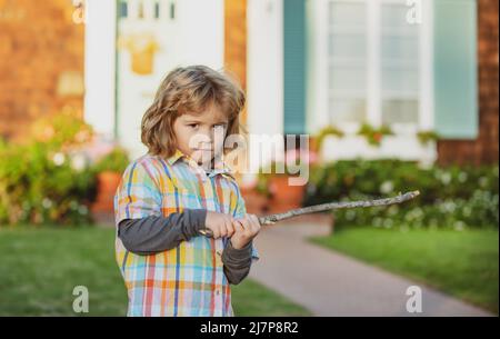 Aggression von Kindern. Negative Emotionen für Kinder. Wütender Junge mit Stock. Anpassung an Kinder. Schläger. Stockfoto