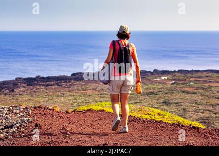 Frau, die auf dem Gipfel des Vulkans Monte Nero, Linosa, läuft. Sizilien. Italien Stockfoto