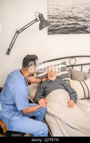 Arzt, der einen kranken Mann besucht Stockfoto