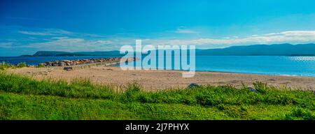 Landschaftlich schöner Strand und Felsmauer mit Bergen im Hintergrund. Sommertag in Nova Scoita Kanada. Stockfoto