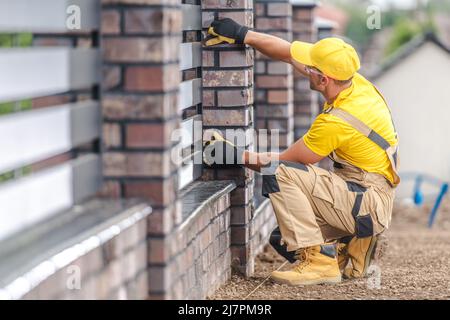 Kaukasischer Bauunternehmer in seinem 40s beengenden dekorativen Wohnzaungebäude. Stockfoto