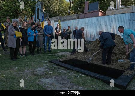 Lviv, Ukraine. 10.. Mai 2022. Die Familie des ukrainischen Soldaten Sergij Michailowitsch Turpetko, der in Popasna in Luhansk getötet wurde, steht an seiner Grabseite im Lytschakiw-Friedhof in Lemberg. Russland marschierte am 24. Februar 2022 in die Ukraine ein und löste damit den größten militärischen Angriff in Europa seit dem Zweiten Weltkrieg aus Kredit: SOPA Images Limited/Alamy Live Nachrichten Stockfoto