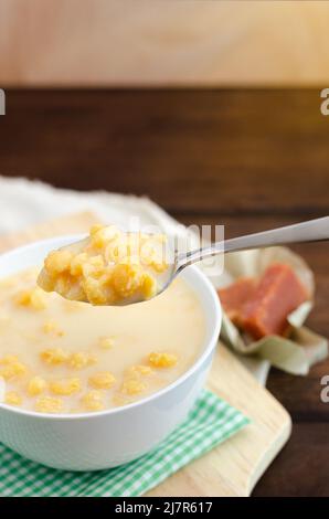 Traditionelles kolumbianisches Essen namens Mazamorra, basierend auf gekochtem Mais, der in Milch aufgelöst wurde, begleitet von süßem Guava (genannt Bocadillo). Dunkler Hintergrund. Stockfoto