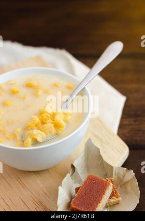 Traditionelles kolumbianisches Essen namens Mazamorra, basierend auf gekochtem Mais, der in Milch aufgelöst wurde, begleitet von süßem Guava (genannt Bocadillo). Dunkler Hintergrund. Stockfoto