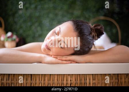 Entspannte Frau, die Kopf in den Händen im Whirlpool ruht Stockfoto