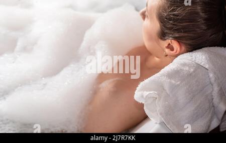 Eine Frau, die sich im Whirlpool mit Seifenschaum entspannen konnte Stockfoto