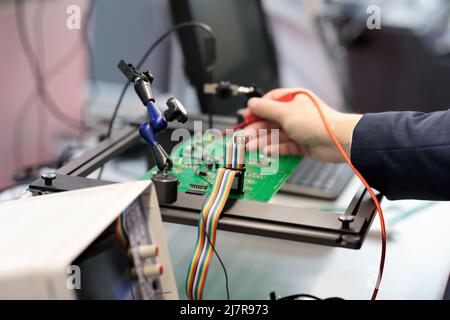 Leiterplattenprüfung und Qualitätskontrolle mit einem Oszilloskop. Selektiver Fokus. Stockfoto