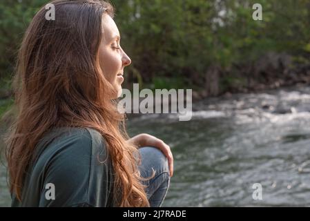 Frau, die das warme Sonnenlicht in der Natur genießt Stockfoto