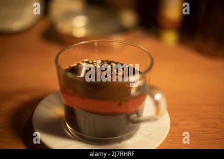 Tasse Tee. Teeblätter in kochendem Wasser. Tee-Party zu Hause. Getränk auf dem Tisch. Stockfoto