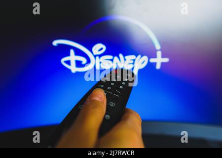 Brasilien. 10.. Mai 2022. In dieser Abbildung zeigt eine Nahaufnahme einer Hand, die eine Fernbedienung hält, die vor dem Disney Plus-Logo auf einem fernsehbildschirm zu sehen ist. (Foto von Rafael Henrique/SOPA Images/Sipa USA) Quelle: SIPA USA/Alamy Live News Stockfoto