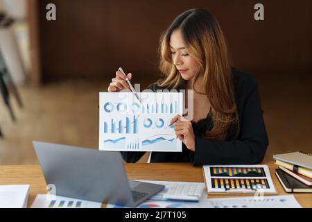 Asian Business Consultant arbeitet zusammen und verwaltet Big Data und analysiert das Finanzbudget des Unternehmens. Fondsinvestitionskonzept. Stockfoto