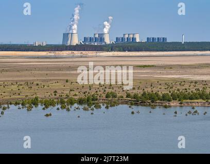 10. Mai 2022, Brandenburg, Cottbus: Blick von einem Aussichtsturm auf die Wasseroberfläche der zukünftigen Cottbuser Ostsee, die im ehemaligen Tagebau Cottbus-Nord entsteht. Im Hintergrund ist das Braunkohlekraftwerk Jänschwalde zu sehen. Hier soll in wenigen Jahren die zukünftige Ostsee Cottbus entstehen. Mitte April 2019 begann die Überschwemmung der ehemaligen Tagebaumine Cottbus-Nord. Das Energieunternehmen Lausitz Energie Bergbau AG (LEAG) lässt für das Hochwasser Wasser aus der Spree über den Hammergraben in den Tagebau fließen. Für Anwohner, t Stockfoto