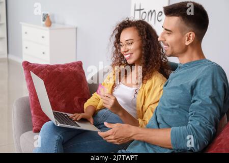 Junges Paar, das zu Hause etwas online auf dem Sofa bestellt Stockfoto