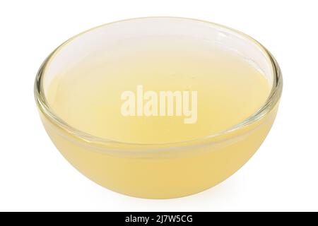 Frisch gepresster Zitronensaft in einer auf Weiß isolierten Glasschüssel. Stockfoto