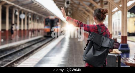 Ziemlich junge Reisende Frau plant Reise am Bahnhof. Sommer- und Reise-Lifestyle-Konzept. Stockfoto