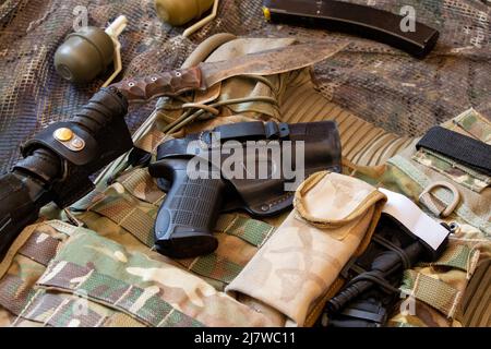 Militärische verstärkte kugelsichere Weste und Pistole, Waffe, Uniform eines ukrainischen Soldaten im Krieg, Armee der Ukraine Stockfoto