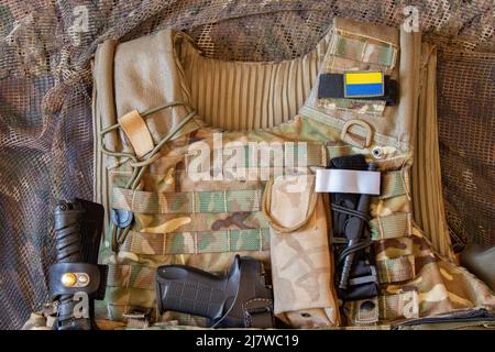 Militärische verstärkte kugelsichere Weste und Pistole, Waffe, Uniform eines ukrainischen Soldaten im Krieg, Armee der Ukraine Stockfoto