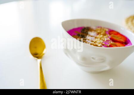 Gesunde Pitaya Raspberry Bowl Smoothie Frühstück in Porzellanschale mit lächelndes Gesicht Stockfoto