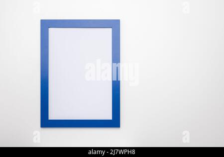 Aufrechter Fotorahmen-Mockup auf weißer Wand. Leerer Diplomrahmen auf weißem Wandhintergrund. Bilderrahmen-Modell. Leerer Diplomrahmen auf weißem Wandhintergr Stockfoto
