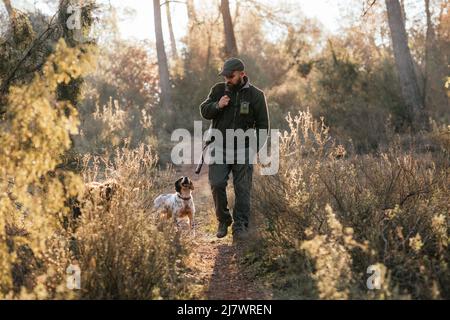 Mann auf der Jagd mit Hund im Herbstwald Stockfoto