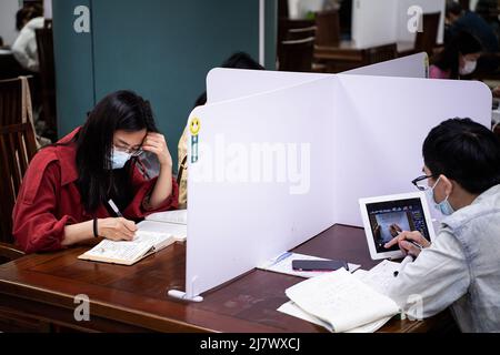 Wuhan, China. 11.. Mai 2022. Als Vorsichtsmaßnahme gegen die Verbreitung von COVID-19 in der Bibliothek Wuhan in Wuhan, China, lesen Bürger mit Gesichtsmasken Bücher mit Trennwänden, die auf jedem Schreibtisch platziert sind, um sich gegenseitig zu trennen. Die Wuhan Bibliothek wurde am Dienstag im Zuge eines neuen COVID-19-Ausbruchs wieder für die Öffentlichkeit geöffnet. (Foto von Ren Yong/SOPA Images/Sipa USA) Quelle: SIPA USA/Alamy Live News Stockfoto