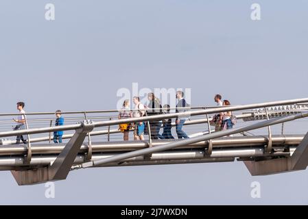 Menschen, die über die Millennium Bridge in London, Großbritannien, laufen. Isoliert gegen den Himmel Stockfoto