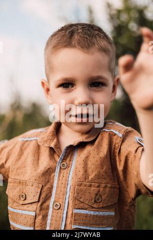 Ein kleiner Junge steht in der Natur und lächelt Stockfoto