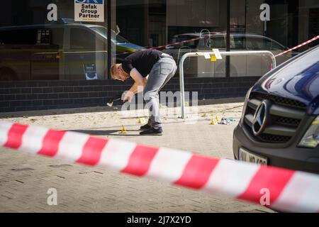 Hanau, Deutschland. 11.. Mai 2022. Forensiker arbeiten auf dem Platz vor einem Hochhaus in der Innenstadt von Hanau, wo heute Morgen ein totes Mädchen gefunden wurde. Vor dem Haus lag ein schwer verletzter Junge auf der Straße. Kredit: Frank Rumpenhorst/dpa/Alamy Live Nachrichten Stockfoto