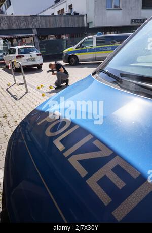 Hanau, Deutschland. 11.. Mai 2022. Forensiker arbeiten auf dem Platz vor einem Hochhaus in der Innenstadt von Hanau, wo heute Morgen ein totes Mädchen gefunden wurde. Vor dem Haus lag ein schwer verletzter Junge auf der Straße. Kredit: Frank Rumpenhorst/dpa/Alamy Live Nachrichten Stockfoto