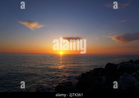 Schöner Sonnenuntergang mit linsenförmigen Wolken und herrlichem Himmel über dem Tyrrhenischen Meer, in Marina di Pisa Stockfoto