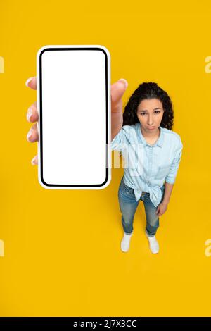 Traurige Dame mit leerem Smartphone-Bildschirm Stockfoto
