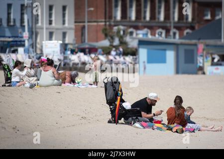 Weymouth, Dorset, Großbritannien. 6. Mai 2022. Tagesausflügler und Urlauber genießen den Strand von Weymouth in Dorset an einem der heißesten Tage des Jahres. Stockfoto
