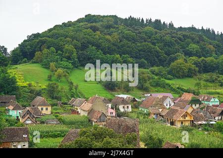 Traditionelle Häuser umgeben von grünen Hügeln im Dorf Biertan, Siebenbürgen, Rumänien Stockfoto