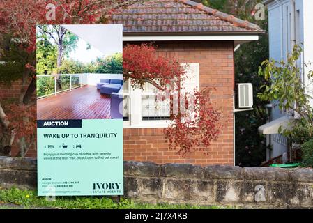 Ein Schild an der Vorderseite eines Hauses, das ein australisches (Ziegeldach) Haus zum Verkauf durch Auktion in Sydney, New South Wales, anwirbt Stockfoto