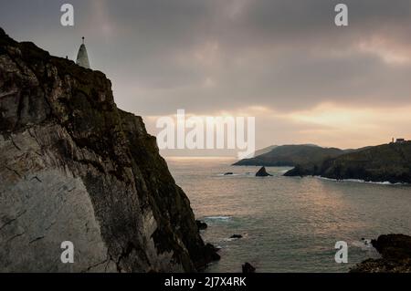 Kegelförmiges Baltimore Beacon und Meeresklippen vor der Küste des kleinen Fischerdorfes Baltimore, Irland. Stockfoto