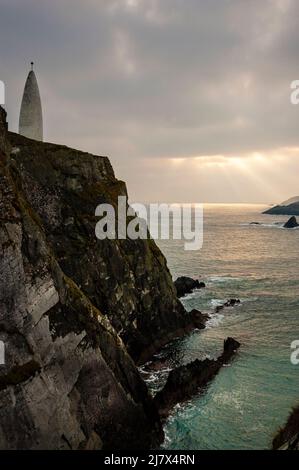 Kegelförmiges Baltimore Beacon und Meeresklippen vor der Küste des kleinen Fischerdorfes Baltimore, Irland. Stockfoto