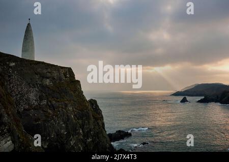 Kegelförmiges Baltimore Beacon und Meeresklippen vor der Küste des kleinen Fischerdorfes Baltimore, Irland. Stockfoto