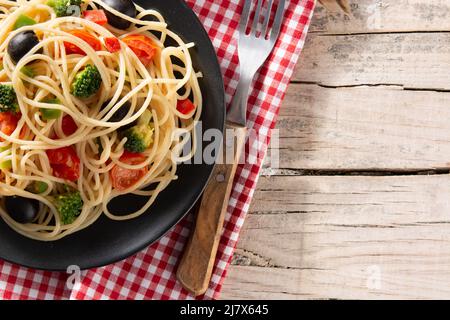 Spaghetti mit Gemüse (Brokkoli, Tomaten, Paprika) auf Holztisch Stockfoto
