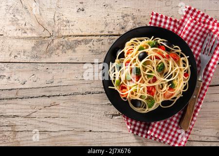Spaghetti mit Gemüse (Brokkoli, Tomaten, Paprika) auf Holztisch Stockfoto