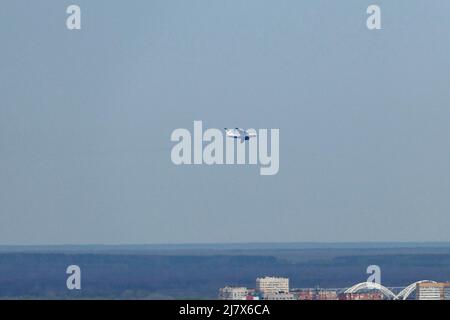 Das Flugzeug fliegt am Himmel über der Stadt. Stockfoto