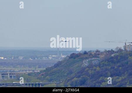 Das Flugzeug fliegt am Himmel über der Stadt. Stockfoto