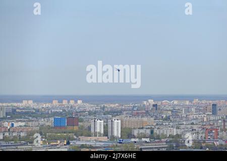 Das Flugzeug fliegt am Himmel über der Stadt. Stockfoto