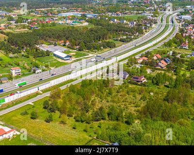 Antenne. Verkehr auf der Intercity-Autobahn zwischen der natürlichen Parklandschaft. Draufsicht von der Drohne. Stockfoto