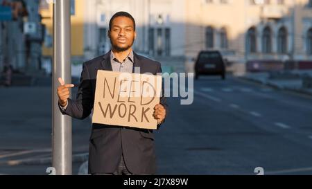 Gemischtes Rennen Geschäftsmann halten Zeichen brauchen Arbeitspunkte Zeigefinger. Porträt eines jungen Mannes, der im Freien steht. Gefeuert tausendjährig männlich weiß Stockfoto