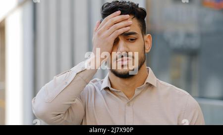 Draußen männlich Porträt traurig hispanischen lateinischen Mann jungen bärtigen Kerl verärgert frustriert stressigen Gefühl verzweifelten Geschäftsmann Blick auf Kamera nahe Gesicht Stockfoto